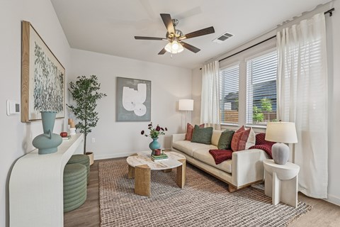 A living room with a white couch and a ceiling fan.