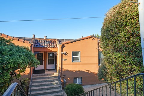 A house with a terrace and a staircase leading to the entrance.