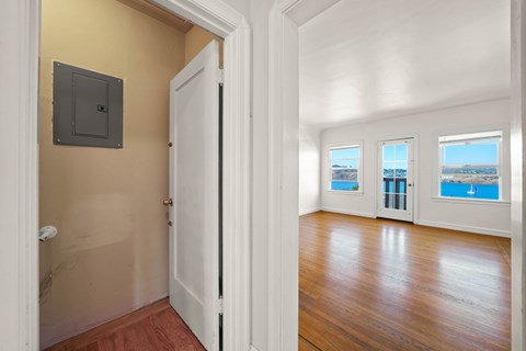 A room with a white door and a window showing a view of the sea.