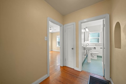 A bathroom with a toilet, sink, and mirror.
