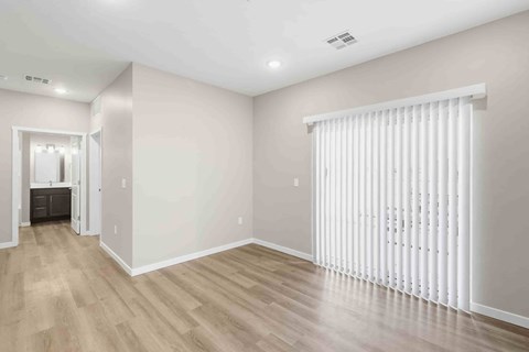 A room with wooden flooring and white walls.