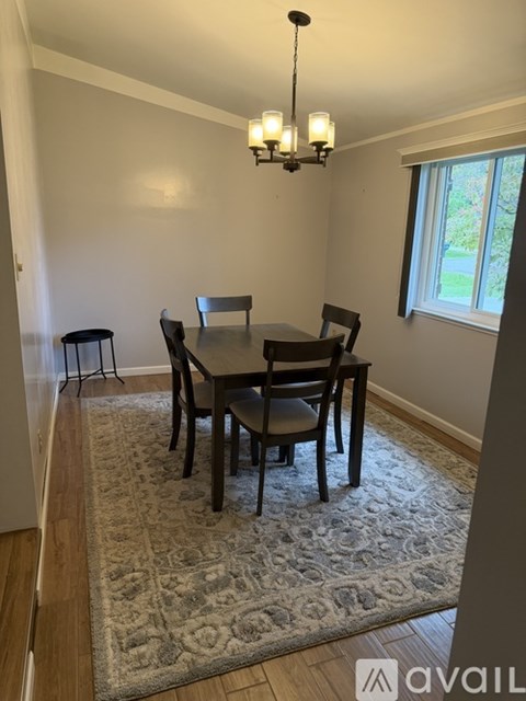 A dining room with a table and chairs.