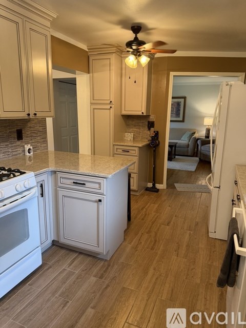 A kitchen with a white stove top oven and a white refrigerator.