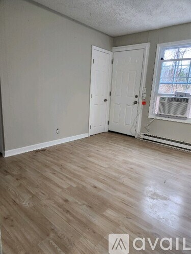 A room with a white door and a window with blinds.
