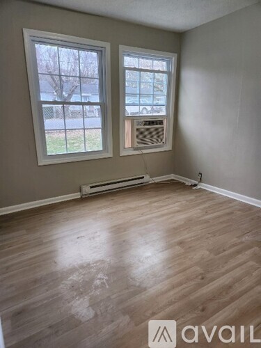 A room with a window and a wall-mounted air conditioner unit.