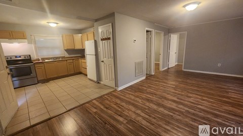 A kitchen with wooden cabinets and a tiled floor.