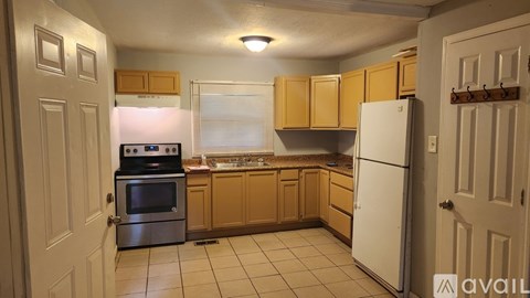 A kitchen with wooden cabinets and a white refrigerator.