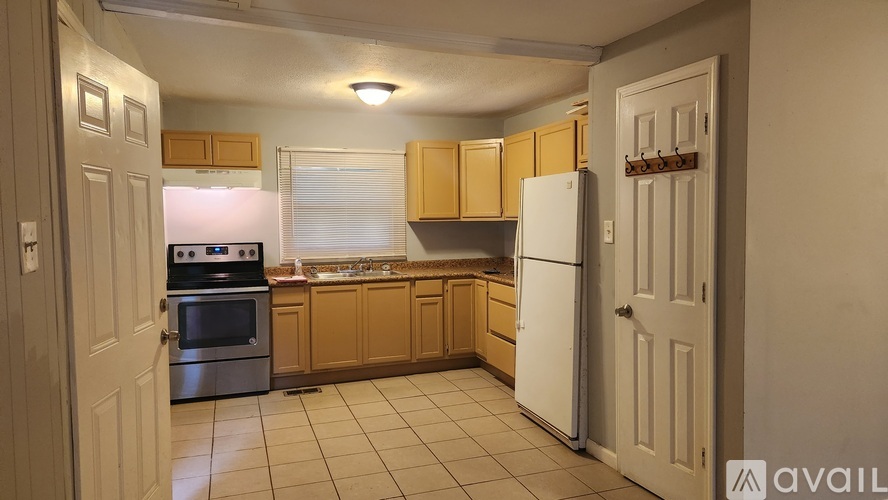 A kitchen with a white refrigerator, wooden cabinets, and a white oven.