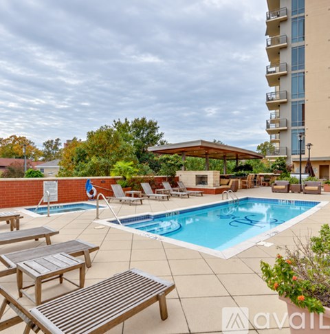 A pool with a wooden bench and a poolside table.