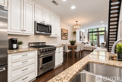 A modern kitchen with white cabinets and stainless steel appliances.