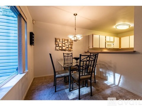 A dining room with a table and chairs.