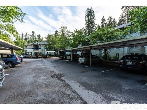 A parking lot with cars and a building in the background.