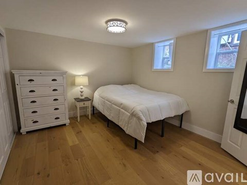 A bedroom with a bed, dresser, and nightstand.