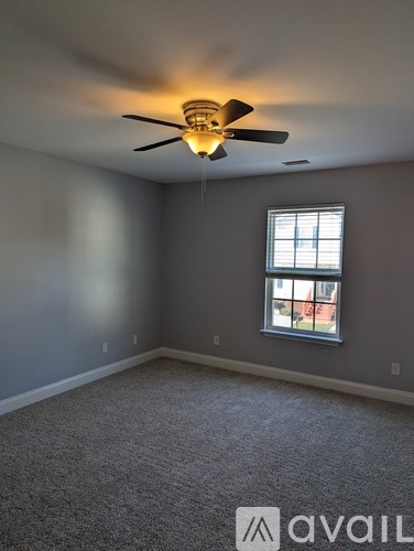 A room with a ceiling fan and a window.