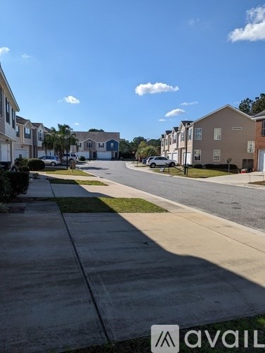 A sunny day in a quiet residential street with houses on both sides.