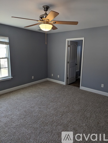 A room with a ceiling fan and a carpeted floor.