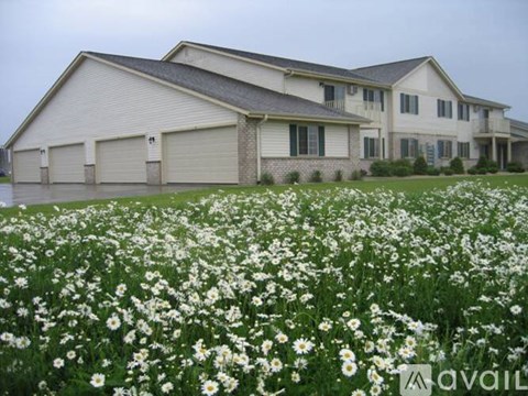 A field of white flowers in front of a house.