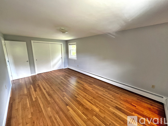 A room with wooden flooring and two doors.