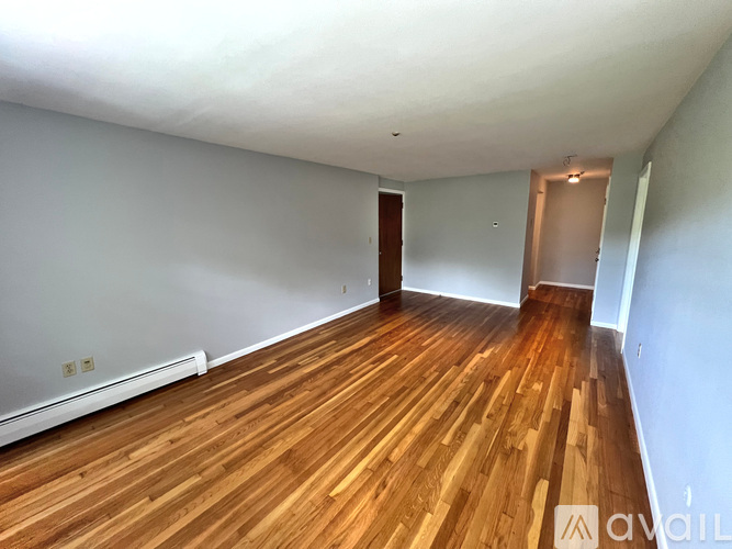 A room with wooden flooring and two doors.