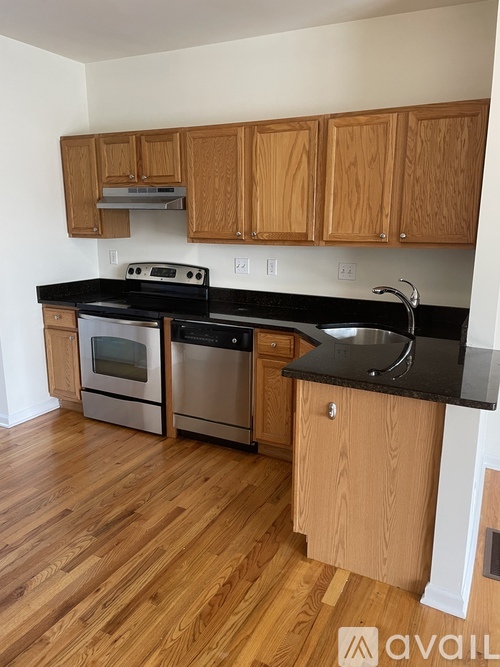 A kitchen with wooden cabinets and black countertops.