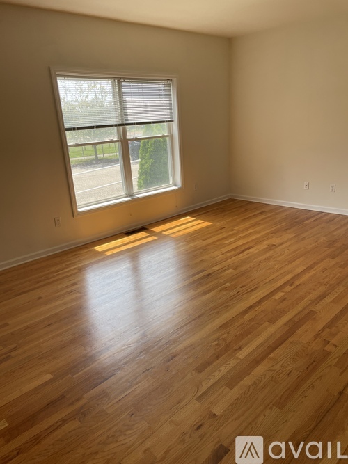 A room with wooden flooring and a window.