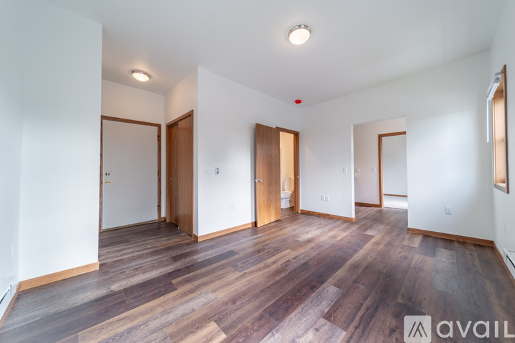 A room with wooden floors and white walls, with a mirror on the wall.