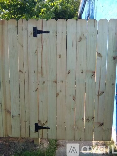 A wooden fence with a black latch is shown.