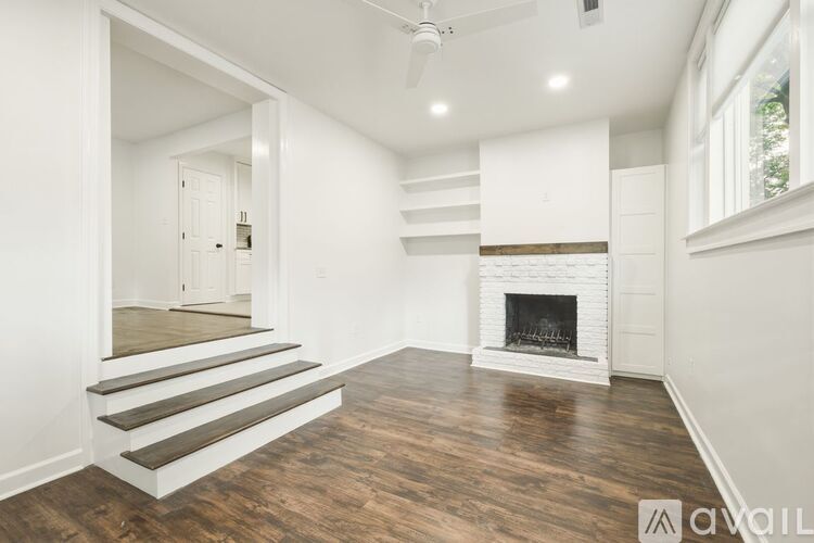 A spacious living room with a fireplace and wooden flooring.