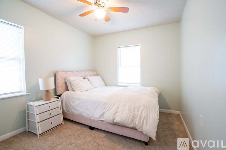 A bedroom with a bed, nightstand, and window.