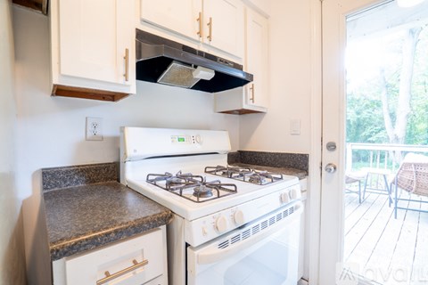 A white stove and oven in a kitchen with wooden cabinets.