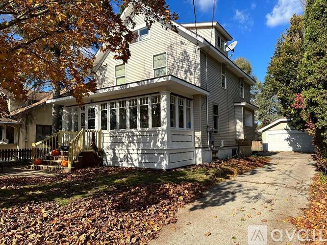A house with a white fence and a porch with a railing.