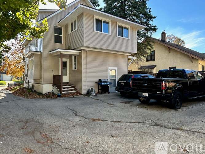 A beige house with a black truck parked in front.