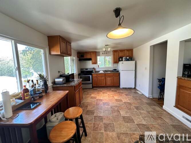 A kitchen with a tile floor and wooden stools.