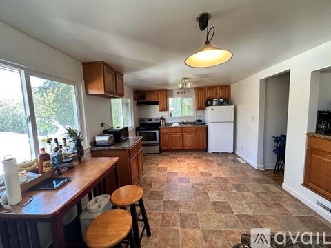 A kitchen with a tile floor and wooden stools.