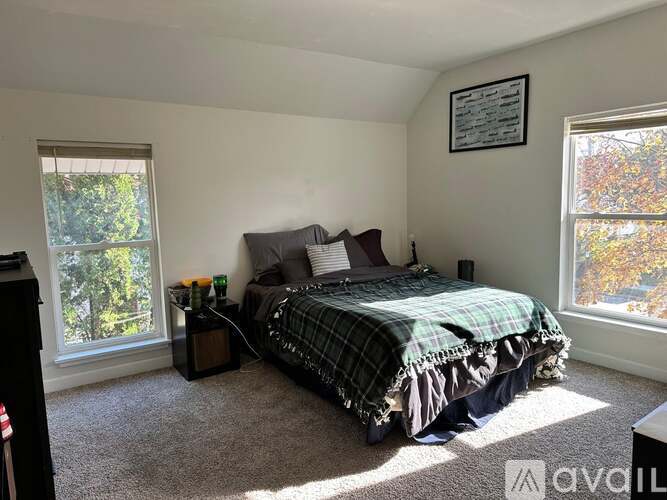 A bedroom with a bed, nightstand, and window.