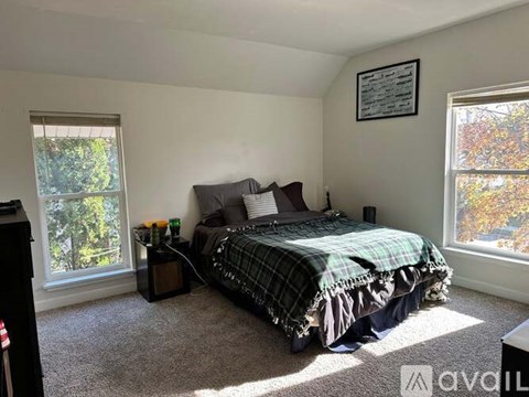 A bedroom with a bed, nightstand, and window.