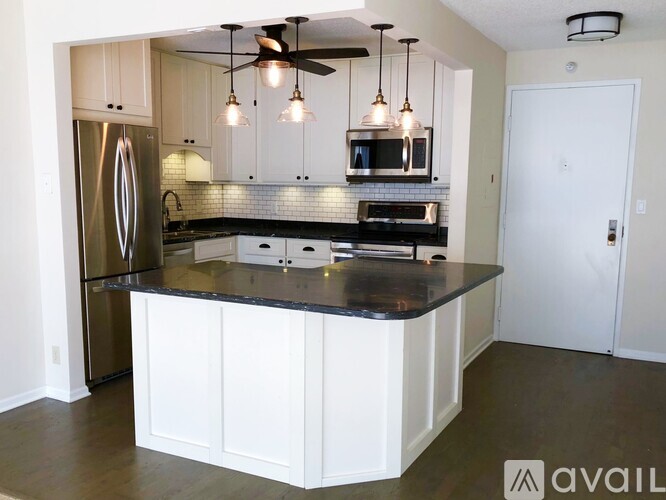 A kitchen with a black countertop and white cabinets.