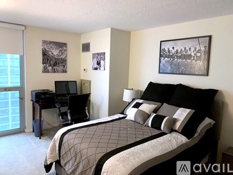 A bedroom with a large bed and a desk with a computer.