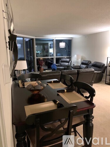A living room with a dark wooden table and chairs.