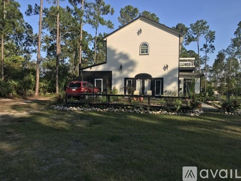 A house with a red car parked in front of it.