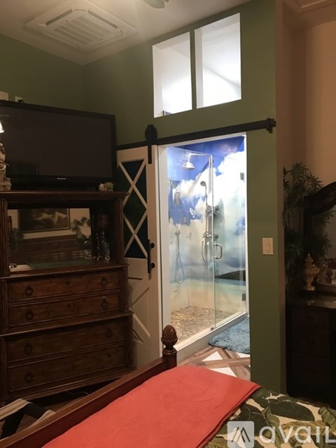 A bedroom with a bed, dresser, and a television.