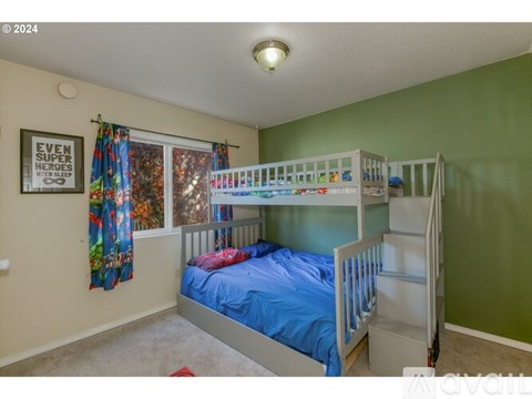 A bedroom with a bunk bed and a window with curtains.