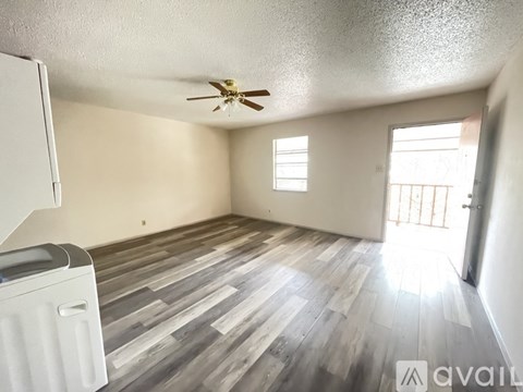 A room with a ceiling fan and wooden flooring.