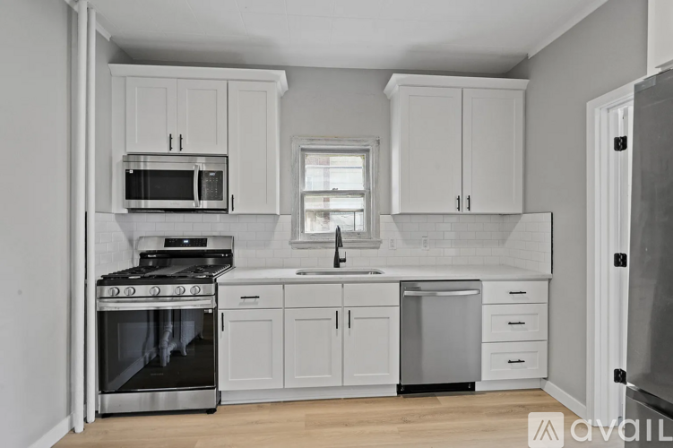 A kitchen with white cabinets and appliances.