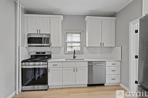 A kitchen with white cabinets and appliances.