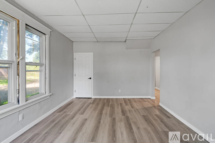 A room with wooden flooring and white walls.