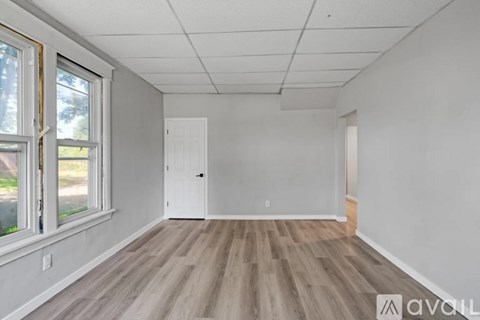 A room with wooden flooring and white walls.
