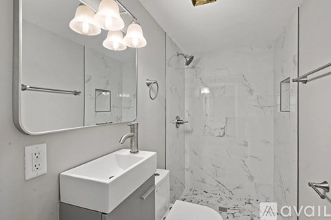A bathroom with a marble wall and a white sink.