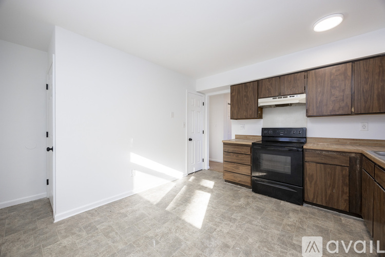 A kitchen with a black oven and wooden cabinets.