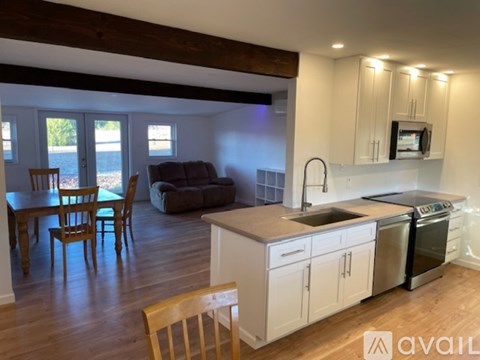 A kitchen with a wooden floor and white cabinets.